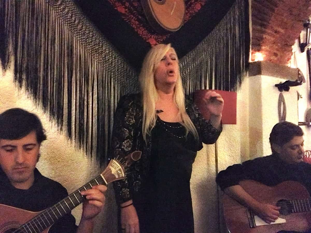 Fado singer and two guitar players perform at a restaurant in Lisbon.