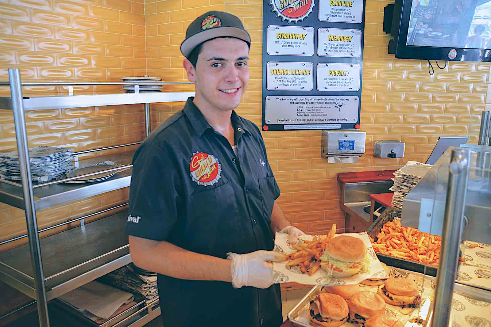 Guy's Burger Joint Line Cook in Uniform serves a Guy Fieri burger. 