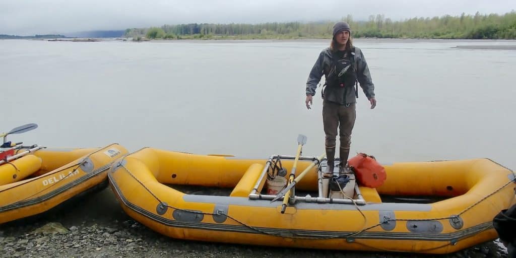 Rafting guide standing on raft for safety talk.