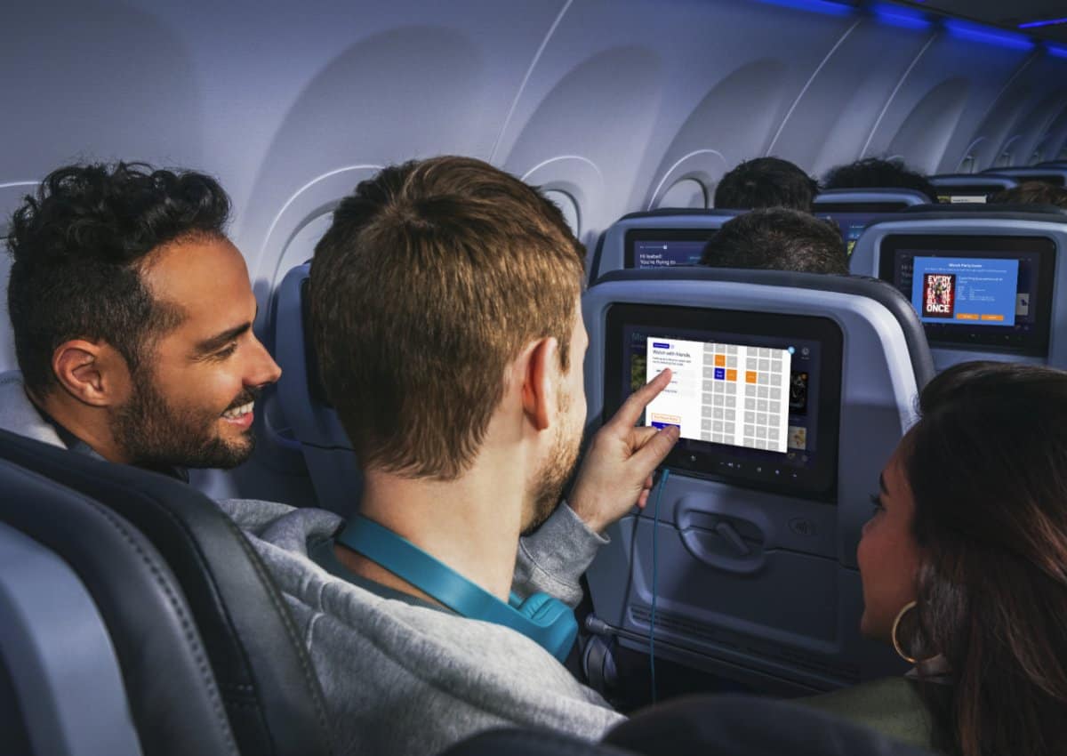 Passengers interacting with their seatback screen on a JetBlue flight.