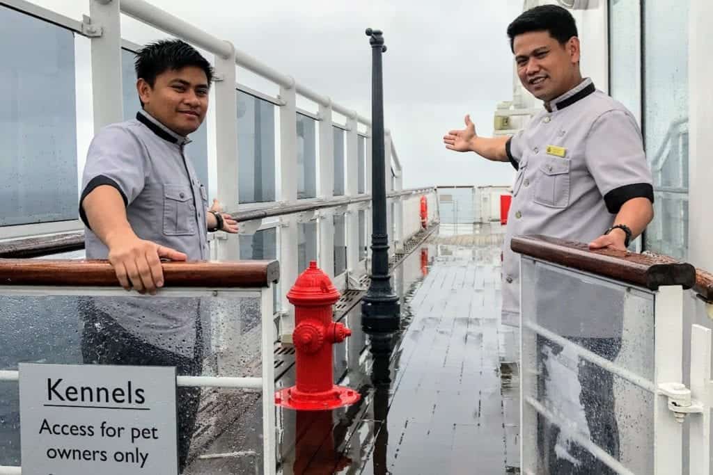 Outdoor entrance to kennels with two kennel masters opening the gate. 