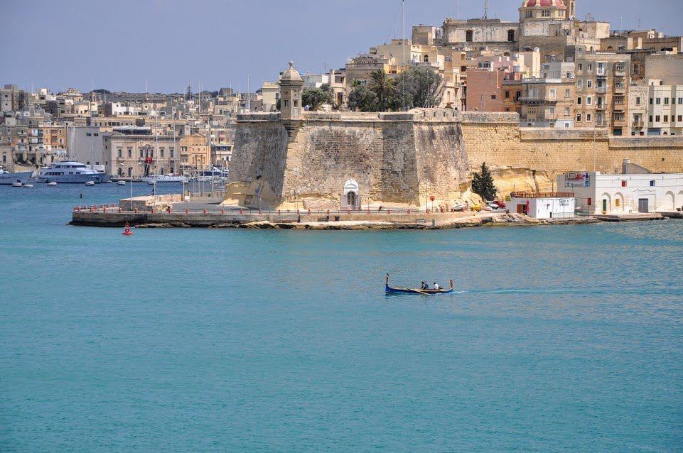 Valletta, Malta harbor with the old fort across the water and a gondola crossing.