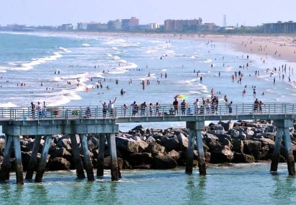 Crowds gather along the Jetty Park pier to wave bon voyage as the ships head out to sea.