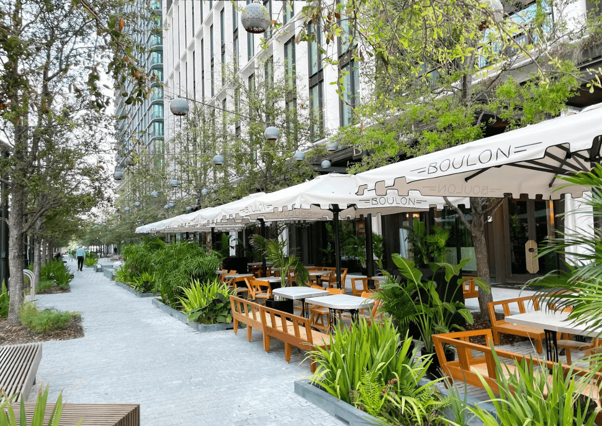 Standing on the sidewalk of Water Street Tampa looking towards a dining patio for a restaurant.